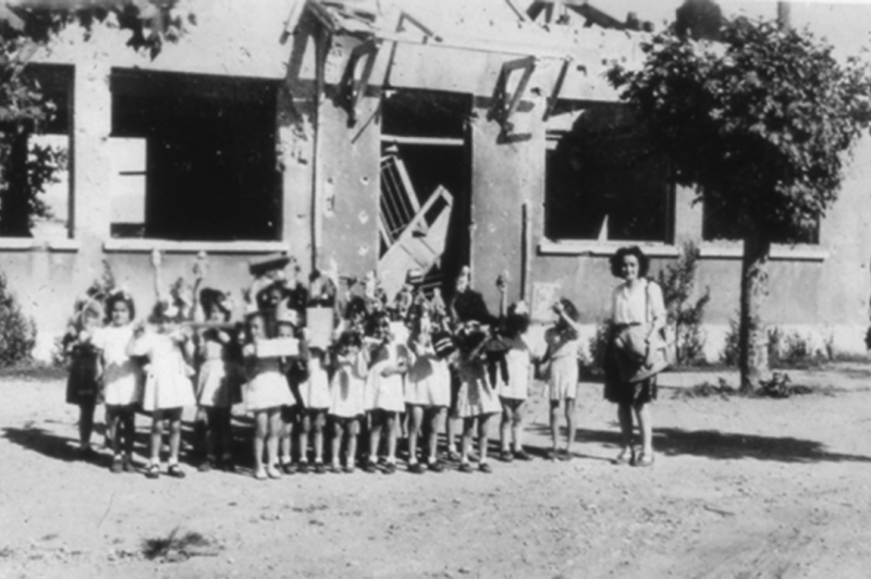 Groupes d'élèves devant l'école de fille détruite lors des bombardements américains d'août 1944